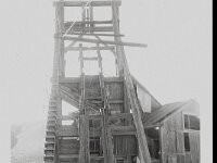 Front view of head frame at Johnnie Mine. Structure appears to be made of wood and connects to the rest of the mining building to the right. Photographic  Johnnie Mine, sometime during the 1940's or 1950's, courtesy UNLV